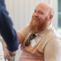 faculty shaking hands at table